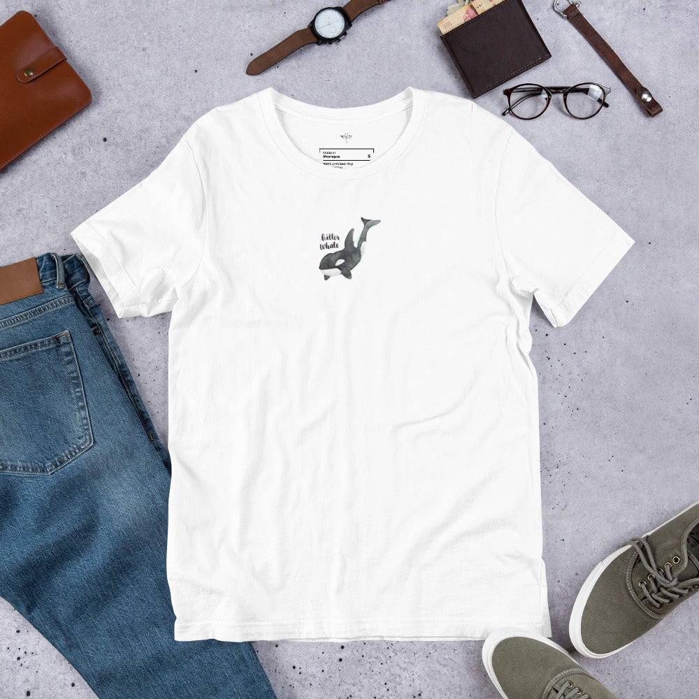 White t-shirt with 'killer whale illustration' on a gray surface with jeans, shoes, and accessories.

