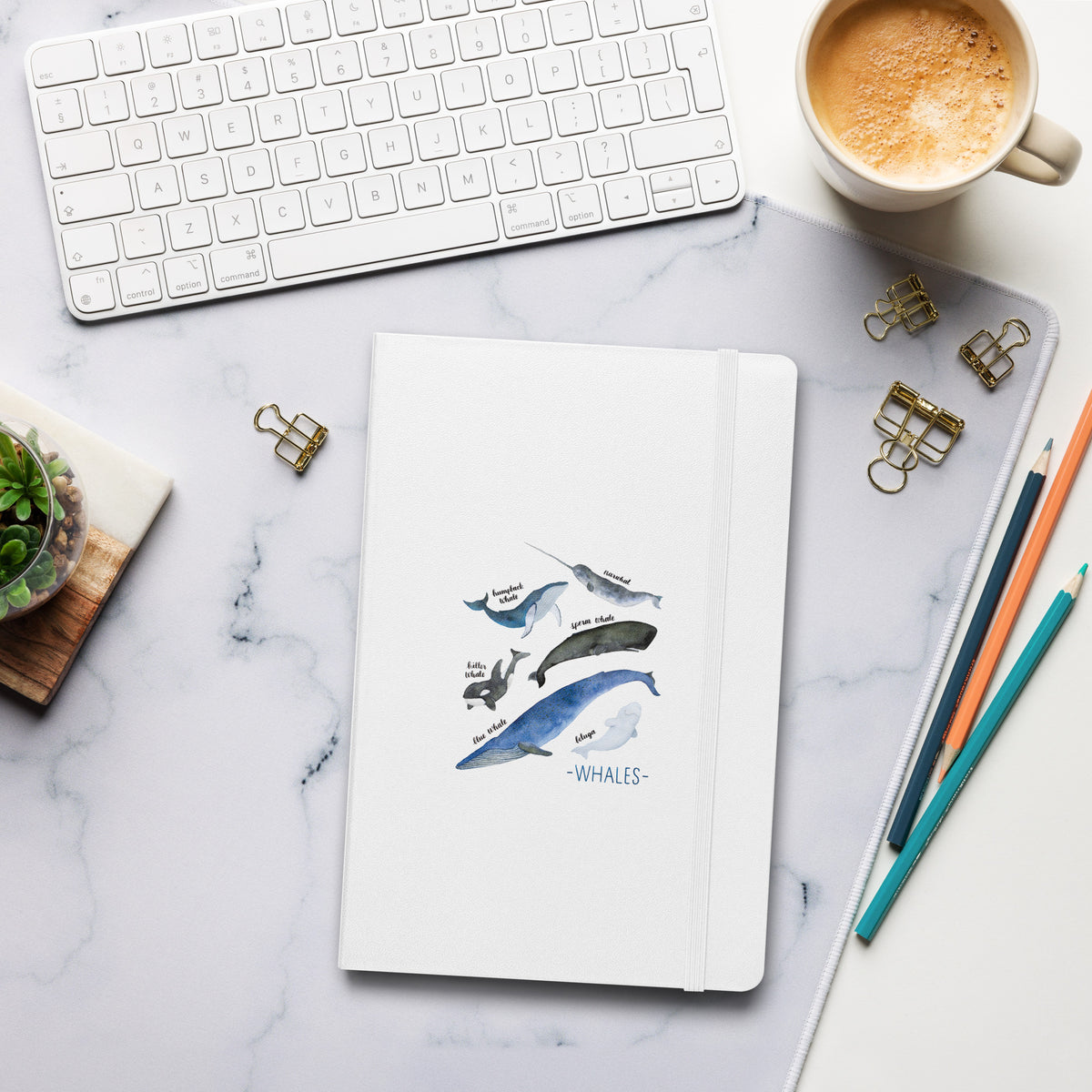 Notebook with Putney logo on a marble desk with keyboard, coffee, and stationery.